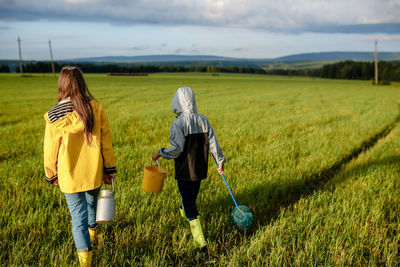 Rear view of women walking on field