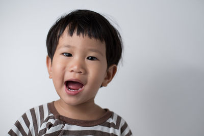 Portrait of cute boy against white background