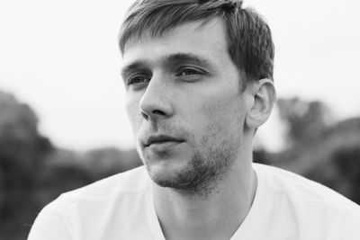 Close-up portrait of mid adult man against sky