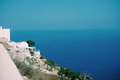Scenic view of sea by building against blue sky