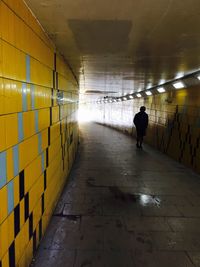 Rear view of people walking in tunnel