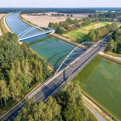 Aerial photograph of infrastructural facilities for cars, trains and ships, overflight of a canal 