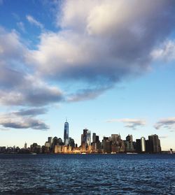 Sea by cityscape against sky