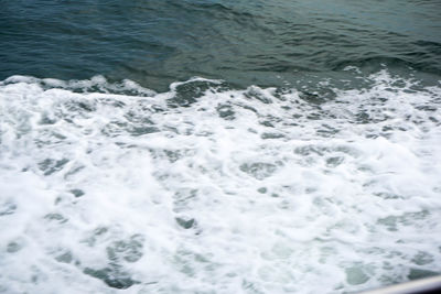 High angle view of waves splashing on sea