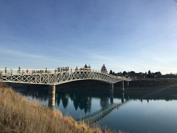 Arch bridge over river against sky