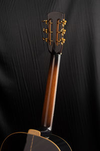 Cropped image of acoustic guitar on bed