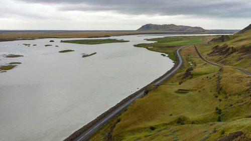 Empty icelandic road on a soggy summer day alongside the glacial river