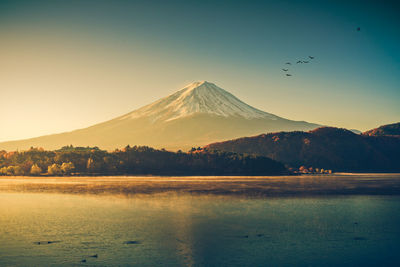 Scenic view of snowcapped mountain against sky during sunset