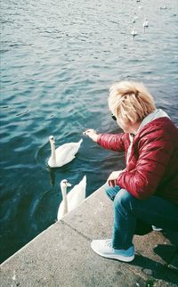 High angle view of woman sitting on a lake