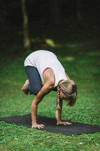 Full length of woman exercising on field