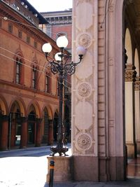 Illuminated street light by building in city