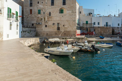 Boats moored on sea by buildings