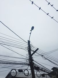 Low angle view of electricity pylon against clear sky