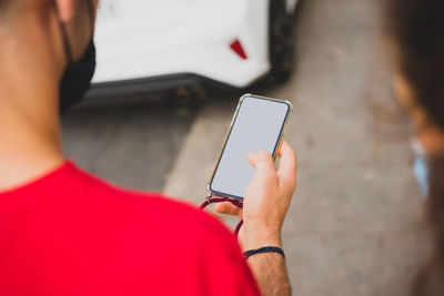 Midsection of man using mobile phone