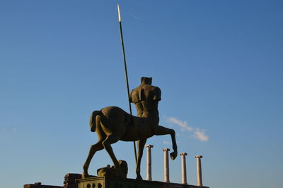 Low angle view of statue against clear sky. centauro