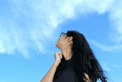 Low angle view of woman against blue sky