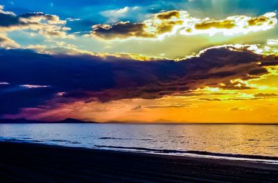 Scenic view of sea against dramatic sky during sunset