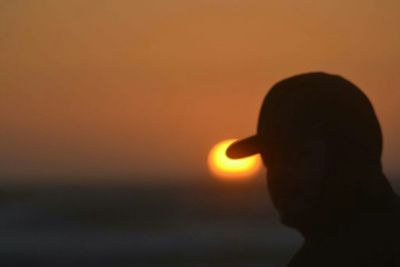 Woman holding camera at sunset