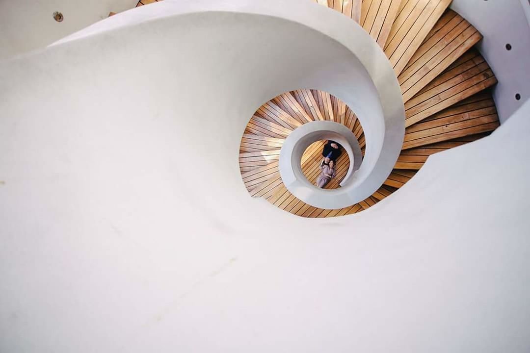 spiral, indoors, architecture, staircase, steps and staircases, built structure, high angle view, copy space, spiral staircase, railing, no people, pattern, day, directly above, design, white color, shape, directly below, ceiling