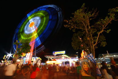 Illuminated ferris wheel in city at night