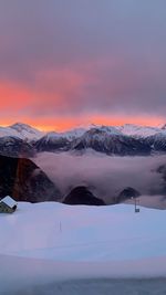 Scenic view of snowcapped mountains against sky during sunset