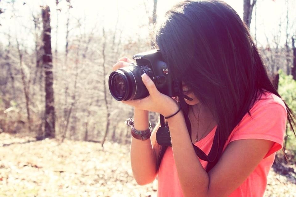 lifestyles, leisure activity, focus on foreground, holding, person, casual clothing, young adult, side view, young women, outdoors, day, long hair, rear view, close-up, sitting