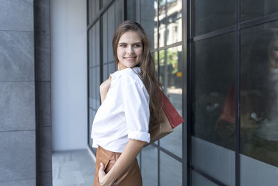 Portrait of woman standing against wall