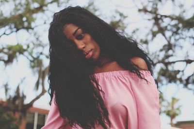Portrait of woman against pink tree