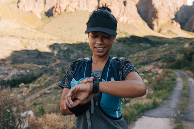 Female hiker checking smart watch outdoors