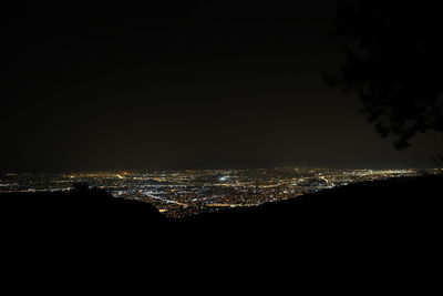 Illuminated city against sky at night