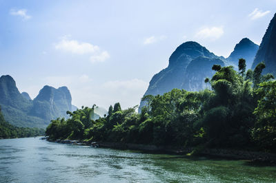 Scenic view of river and mountains against sky