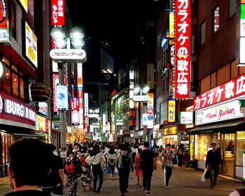 People walking on city street at night