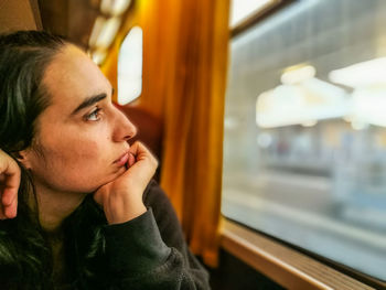 Close-up of woman looking through window