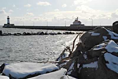 Lighthouse on beach against sky