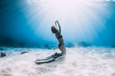 Rear view of man jumping in sea