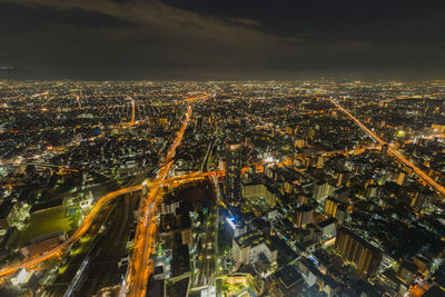 High angle view of illuminated city against sky at night