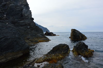 Rock formations by sea against sky