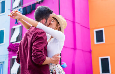 Young couple standing on pink outdoors