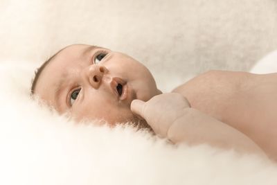 Close-up of cute newborn baby lying on bed