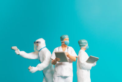 Men standing against blue background