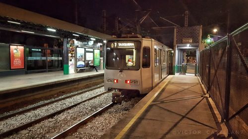 Train at railroad station platform at night