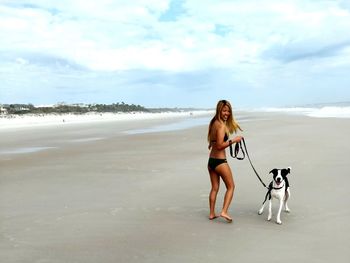 Smiling woman with dog at beach