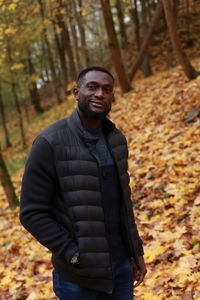 Portrait of man standing in forest during autumn