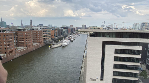 River amidst buildings in city against sky