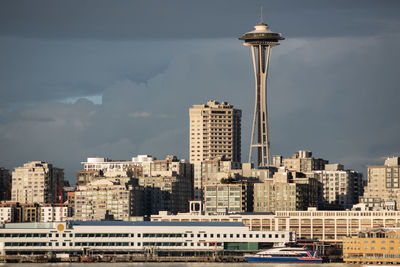 Modern buildings in city against cloudy sky