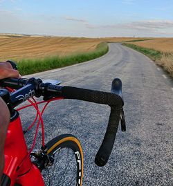 Man riding bicycle on road against sky