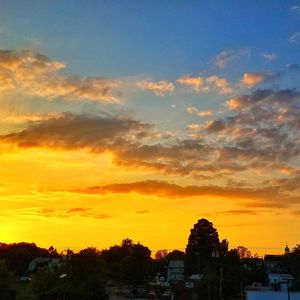 Houses in town against sky during sunset