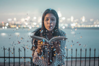 Portrait of young woman standing against sea