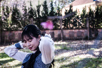 Side view of woman standing against plants