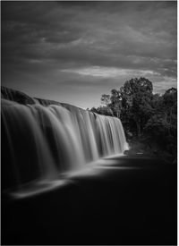 Scenic view of waterfall against sky